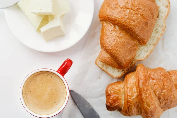 Breakfast with cup of coffee and croissants with butter — Stock Photo, Image