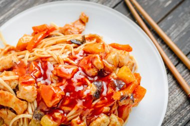 Tavuk ve sebze plaka ve çubuk siyah ahşap zemin üzerine Udon heyecan fry noodles