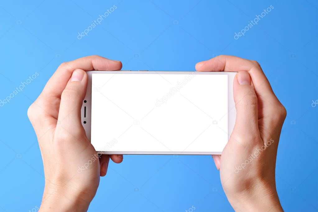 Woman holding mobile phone with blank screen on blue background