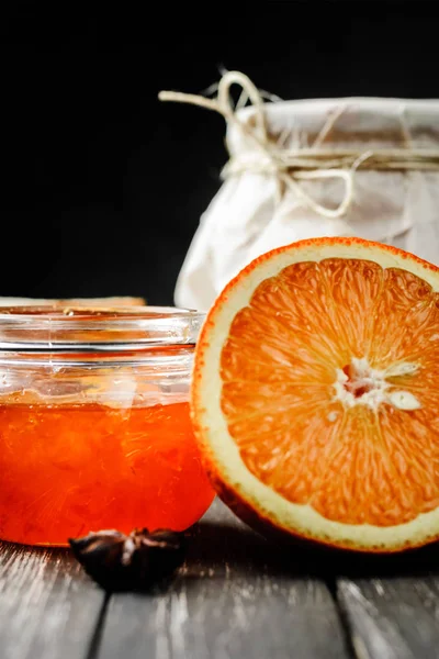Engarrafamento de laranja em vidro e fatia de laranja no fundo de madeira — Fotografia de Stock