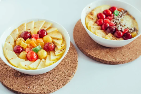 Hälsosam frukost. Gröt med körsbär, äpple och kanderad frukt på vit bakgrund — Stockfoto