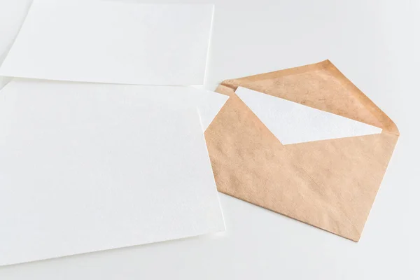 Maquette de l'enveloppe et papier blanc vierge sur fond blanc — Photo