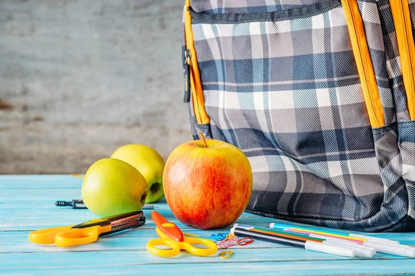 Äpfel und Schulrucksack auf Holzgrund. — Stockfoto