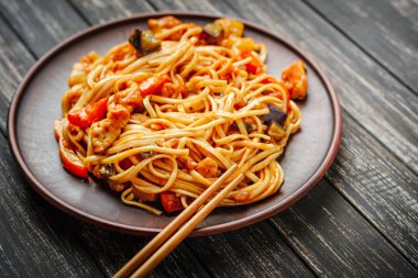 Et ve sebze sos ve çubuk siyah ahşap zemin üzerine Udon heyecan fry noodles