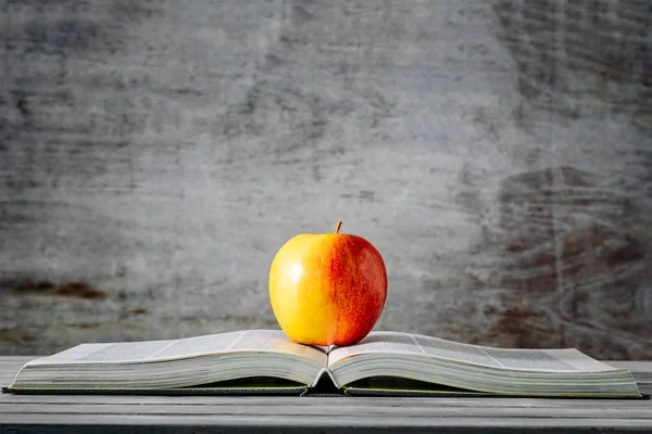 Roter Apfel Auf Offenem Buch Mit Grauem Holzhintergrund — Stockfoto