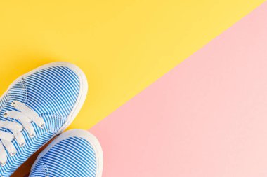 sarı ve pembe pastel arka plan en iyi görünüm düz mavi soyulmuş spor ayakkabı yatıyordu