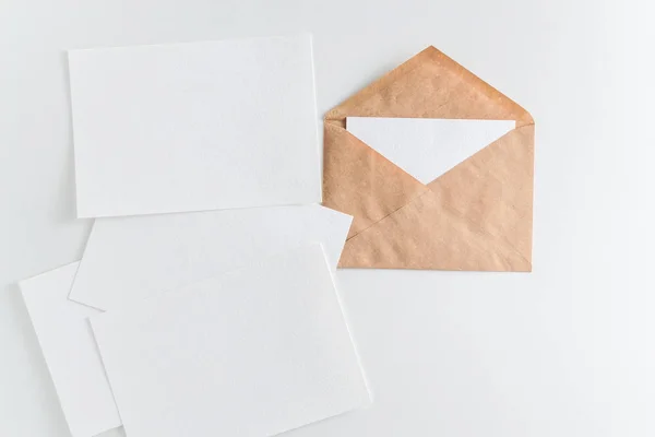 白い背景の上のモックアップ茶色のクラフト封筒と炭酸水の空きカード — ストック写真