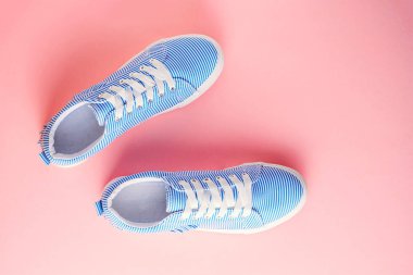 Mavi çizgili erkek spor ayakkabı pastel pembe bir arka plan üzerinde. Düz yatıyordu, en iyi görünümü