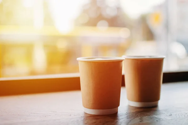 Tasses en papier de café près de la fenêtre du café — Photo