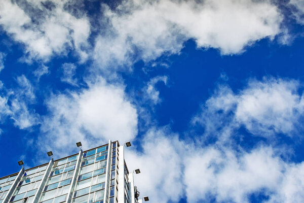 Modern office building against blue cloudy sky