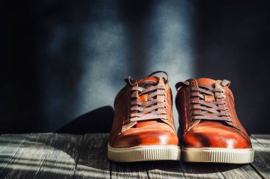 Koyu ahşap arka plan kopya alanı ile kahverengi deri erkek bot