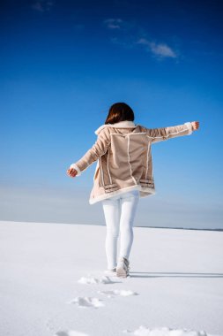 Mutlu genç kadın doğa keyfini çıkarın. Özgürlük kavramı. Karda yürüme ve ellerini kaldırdı kız