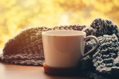 Sonbahar günü sıcak evde. Yün, ipek eşarp ve pencere üzerinde çay