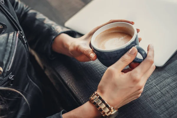 Jovem mulher em um café está segurando xícara de café nas mãos. Pausa para almoço — Fotografia de Stock