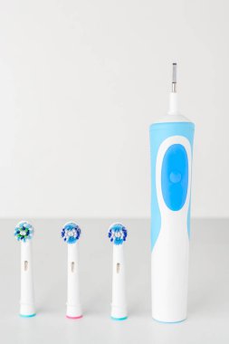 Elektrikli diş fırçası ve yedek fırça uçları beyaz bir arka plan üzerinde Kapat