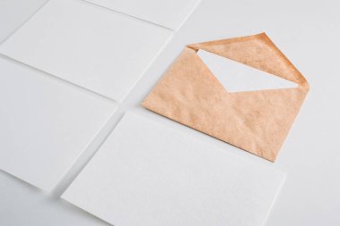 Beyaz kağıt boş çarşafları kartları ve kraft zarf beyaz bir arka plan üzerinde. Mockup tasarım için