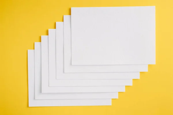 Papier blanc feuilles vides cartes sur un fond jaune. Maquette pour le design — Photo
