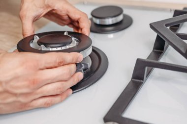 Adam el yükleme brülör ongas hob yılında kithen, yakın çekim. Gaz kontrol panelinin onarımı