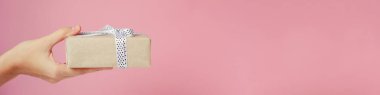 Hediye kutusu pembe arka plan, kopya alanı ile banner üzerinde kadın eli tutar