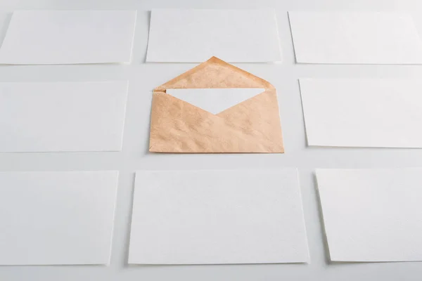 Beyaz kağıt boş çarşafları kartları ve kraft zarf beyaz bir arka plan üzerinde. Mockup tasarım için — Stok fotoğraf