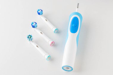 Elektrikli diş fırçası ve yedek fırça başları beyaz arka plan üzerinde Kapat