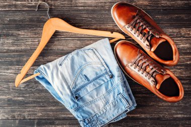 Kahverengi deri rahat ayakkabılar ve koyu ahşap arka plan kot görünümü top. Moda kavramı