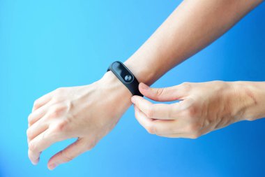 Kadın el ile mavi bir arka plan üzerinde fitness trecker