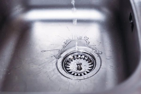 Agua corriendo del grifo al fregadero de la cocina. Concepto de ahorro de agua dulce — Foto de Stock