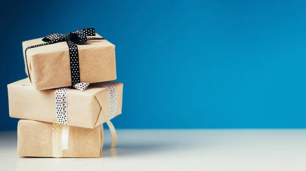 Tre confezione regalo con fiocco a nastro su sfondo blu con spazio per la copia — Foto Stock