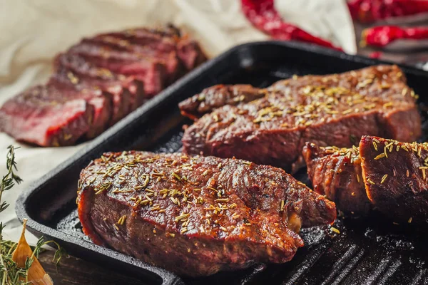 Gegrilde biefstuk op koekenpan, bovenaanzicht. Gebakken brokken vlees close-up — Stockfoto