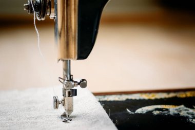 Bağbozumu dikiş makinesi ve giyim öğesi bir parçası. Çelik iğne yatağı (Komple) ve presser ayak yakın çekim ile.