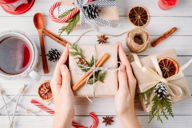 Kadın el hediye kutusu beyaz ahşap zemin, üstten görünüm üzerinde Noel süslemeleri ile kaydırma