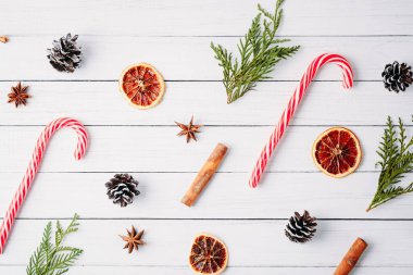 Noel şekerler, çam kozalakları ve beyaz ahşap zemin üzerinde kurutulmuş portakal desen. Noel süsleri