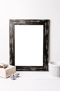 Boş beyaz çerçeve kadar sahte. Siyah ahşap çerçeve mockup beyaz bir arka plan üzerinde Noel süslemeleri ile
