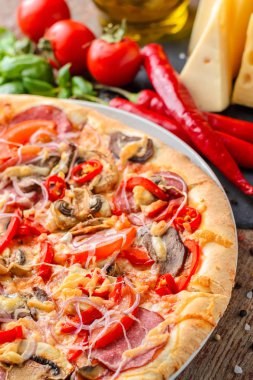 Meksika baharatlı pizza ve malzemelerin üzerine ahşap bir masa. Geleneksel İtalyan mutfağı. Parti gıda