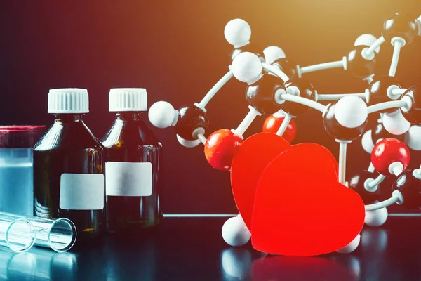 Dois corações de papel vermelho e modelo de estrutura molecular num fundo preto. Conceito de química do amor — Fotografia de Stock