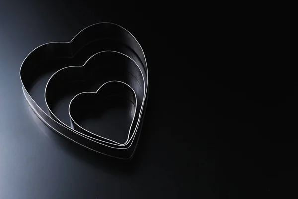 Dough cutter in shape of heart on a dark background with copy space. Valentines Day background