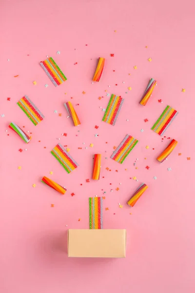 Coloridos caramelos y caja sobre un fondo rosa, vista superior, puesta plana. Moda de moda Estilo — Foto de Stock