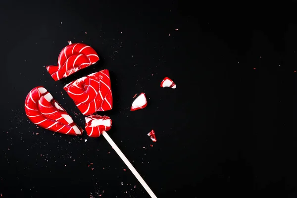 Kopya alanı ile karanlık bir arka plan üzerinde kalp şeklinde lolipop kırık