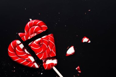 Kopya alanı ile karanlık bir arka plan üzerinde kalp şeklinde lolipop kırık