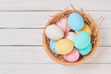 Renkli Paskalya yumurtaları bir ahşap kase, kopya alanı ile üstten görünüm