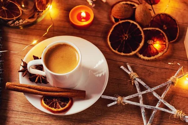 Уютный дом. Чашка кофе с праздничными украшениями и гирляндами — стоковое фото