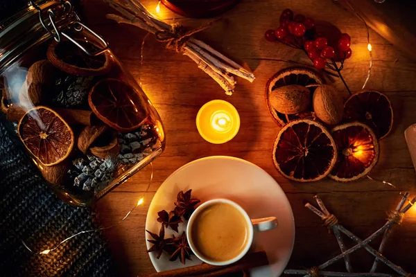 Cup of coffee, candles and decorations with a garland lights, top view