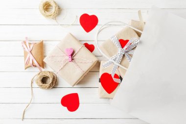 hediye kutuları, kağıt beyaz ahşap zemin üzerinde kalp ve alışveriş çantası kes. Sevgililer günü süsleri