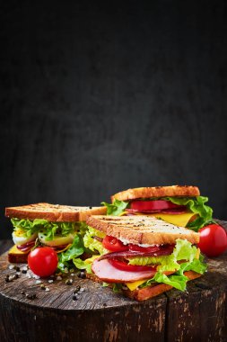 Marul, jambon, domates ve soğan koyu arka plan üzerinde sandviç