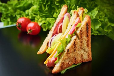 jambon, marul ve karanlık bir arka plan üzerinde taze sebze sandviç