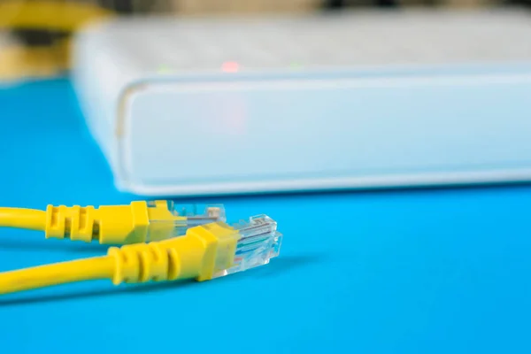 Kabel dan router internet unplugged pada latar belakang biru — Stok Foto