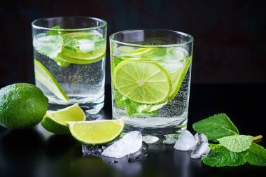 Yaz İçecek limonata mojito limon, nane ve buz üstünde siyah bir arka plan ile