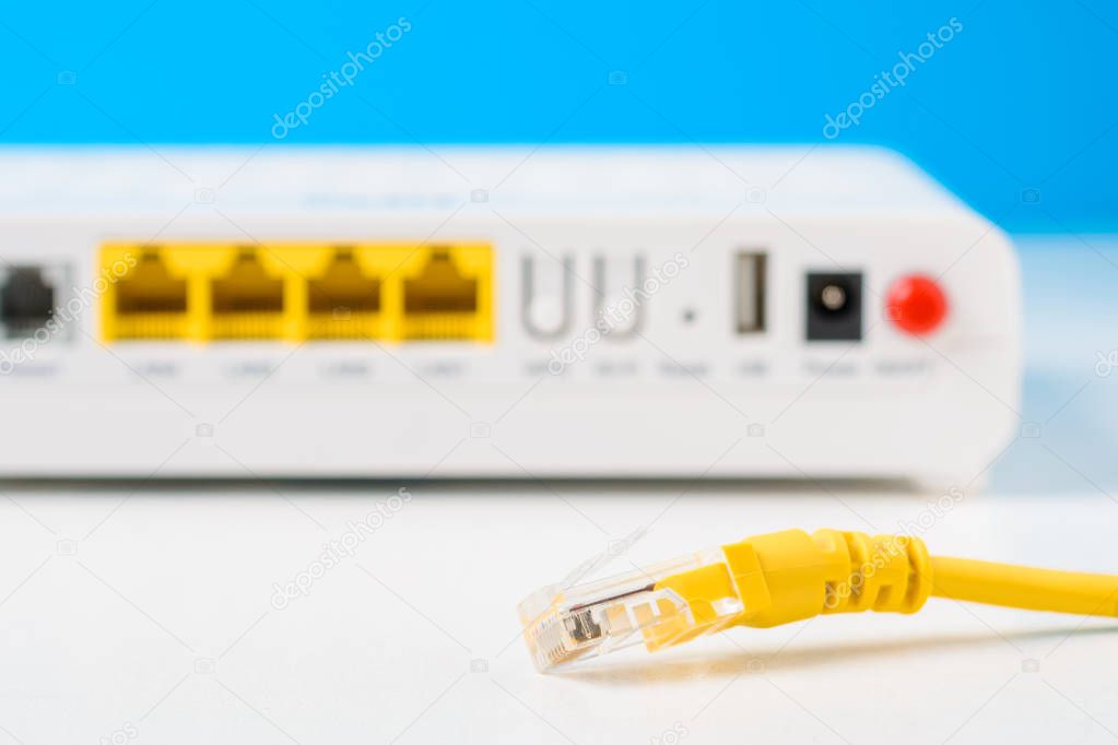 unplugged ethernet cable and internet router on a blue background