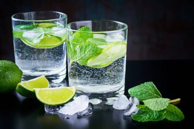 Yaz İçecek limonata mojito limon, nane ve buz üstünde siyah bir arka plan ile
